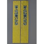 Two Chinese yellow silk panels embroidered with flowers. 103cm tall