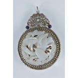 A Chinese carved white jade fitted into a metal pendant.