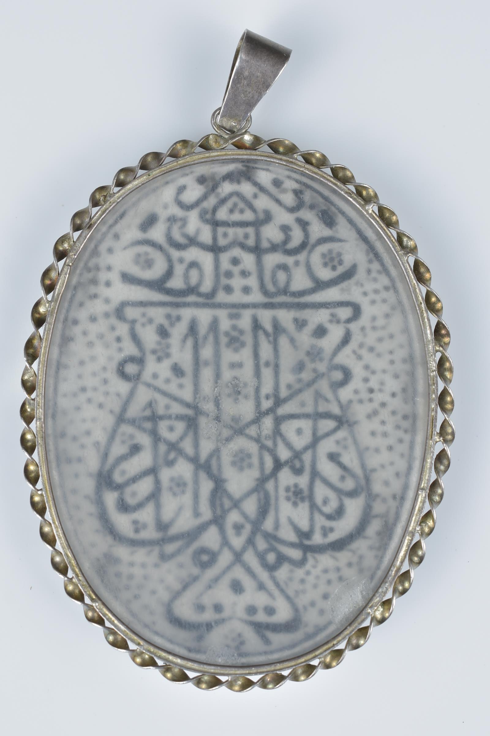 A Persian white metal pendant with inscription. - Image 2 of 2