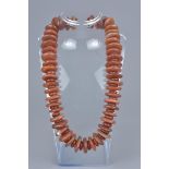A string of red agate beads in a necklace.