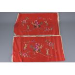 A mirrored pair of Chinese 19/20th century red ground silk embroidered panels with figures and kilin