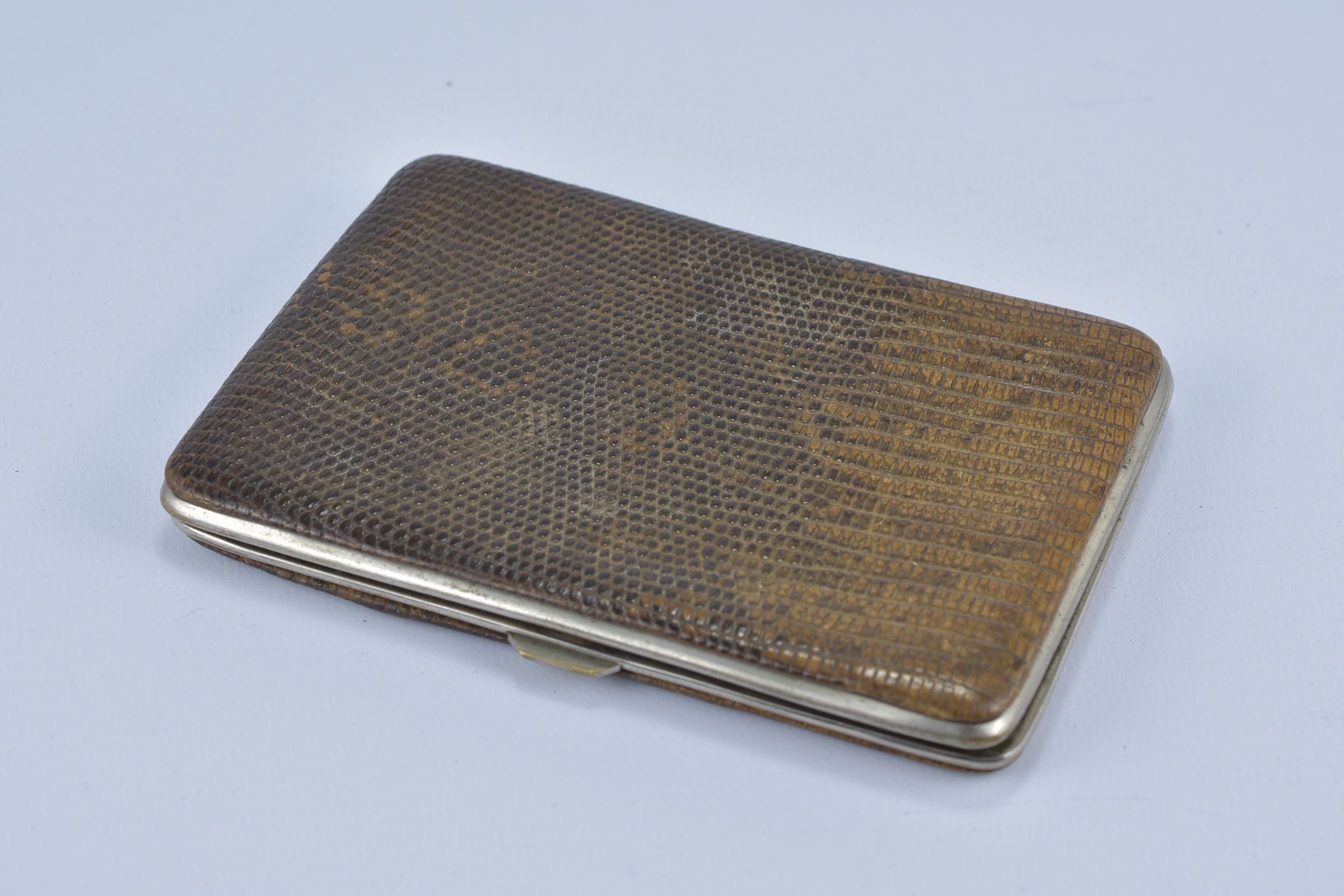 An English antique snake skin leather card case with metal casing.