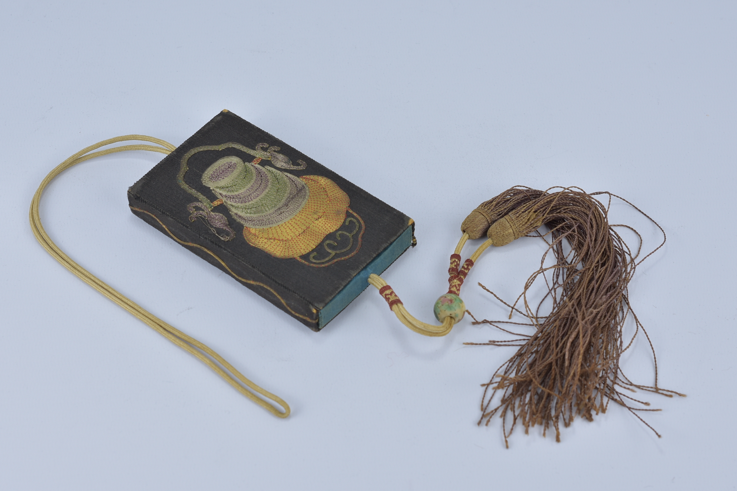 A 19/20th century Chinese embroidered card case with tassel and wire decoration.