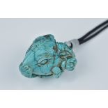 A turquoise carving of a ram's head.