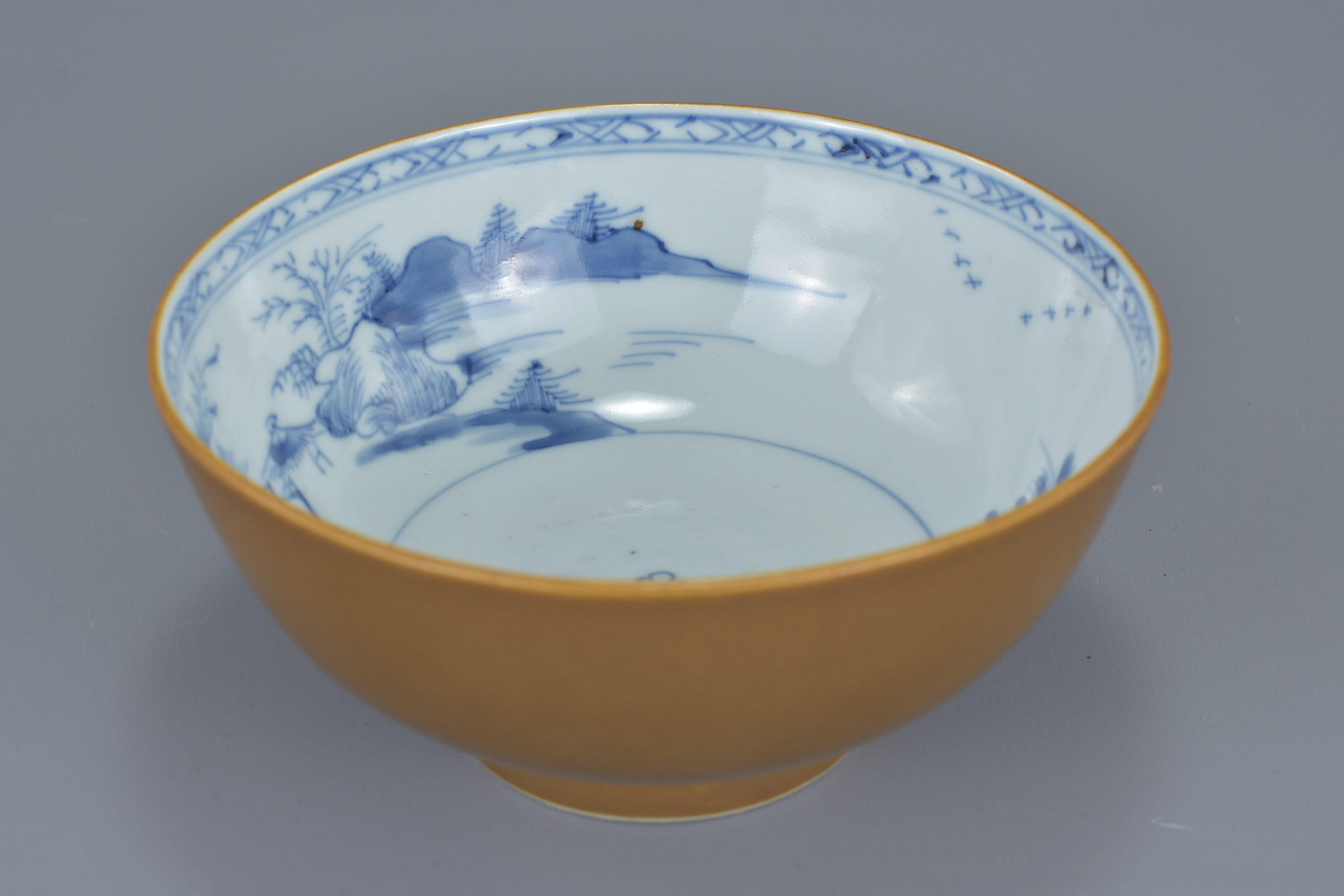 A Chinese 18th century tea-dust brown glazed export porcelain bowl with underglaze blue interior dep