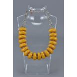 Necklace with 18 Long Amber Coloured Beads spaced with small Amber Chips held on a White Metal Link