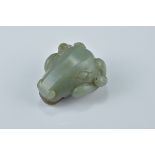 A Chinese dark green and brown jade pendant carved as a rams head. 5cm x 4.5cm