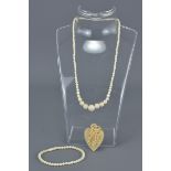 Ivory Heart Shaped Pendant with relief carving of Vines and Grapes together with a String of Graduat