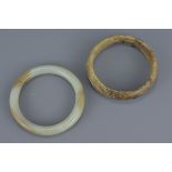 Two Chinese jade bangles. One carved with three dragons. Approx. 8Cm diameters (2)