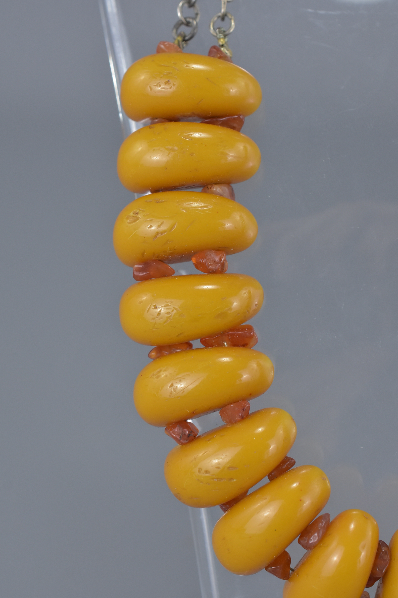 Necklace with 18 Long Amber Coloured Beads spaced with small Amber Chips held on a White Metal Link - Image 3 of 4