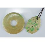 A Chinese jadeite greenish yellow disc together with a jadeite pendant carved as a peach. Disc 5.3cm