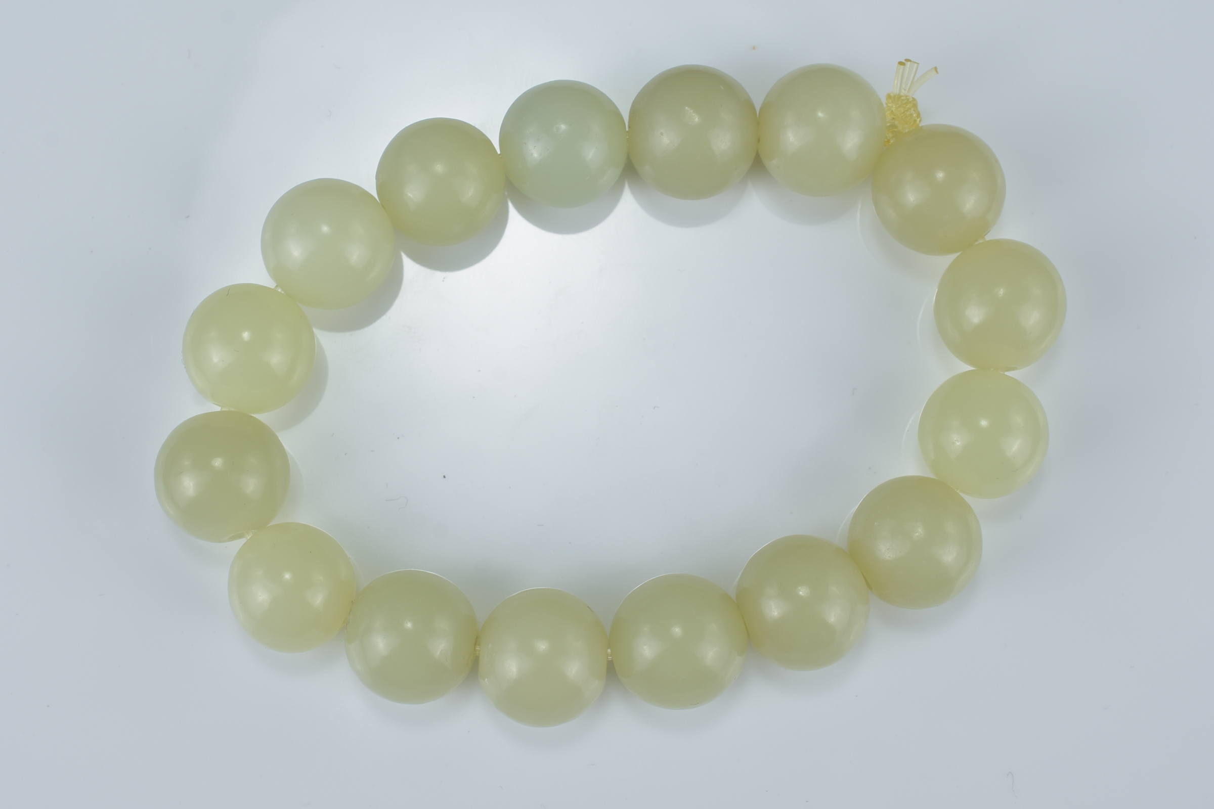 A Chinese pale green jade beaded bracelet. Total 16 beads. Beads approx. 2.3cm diameter