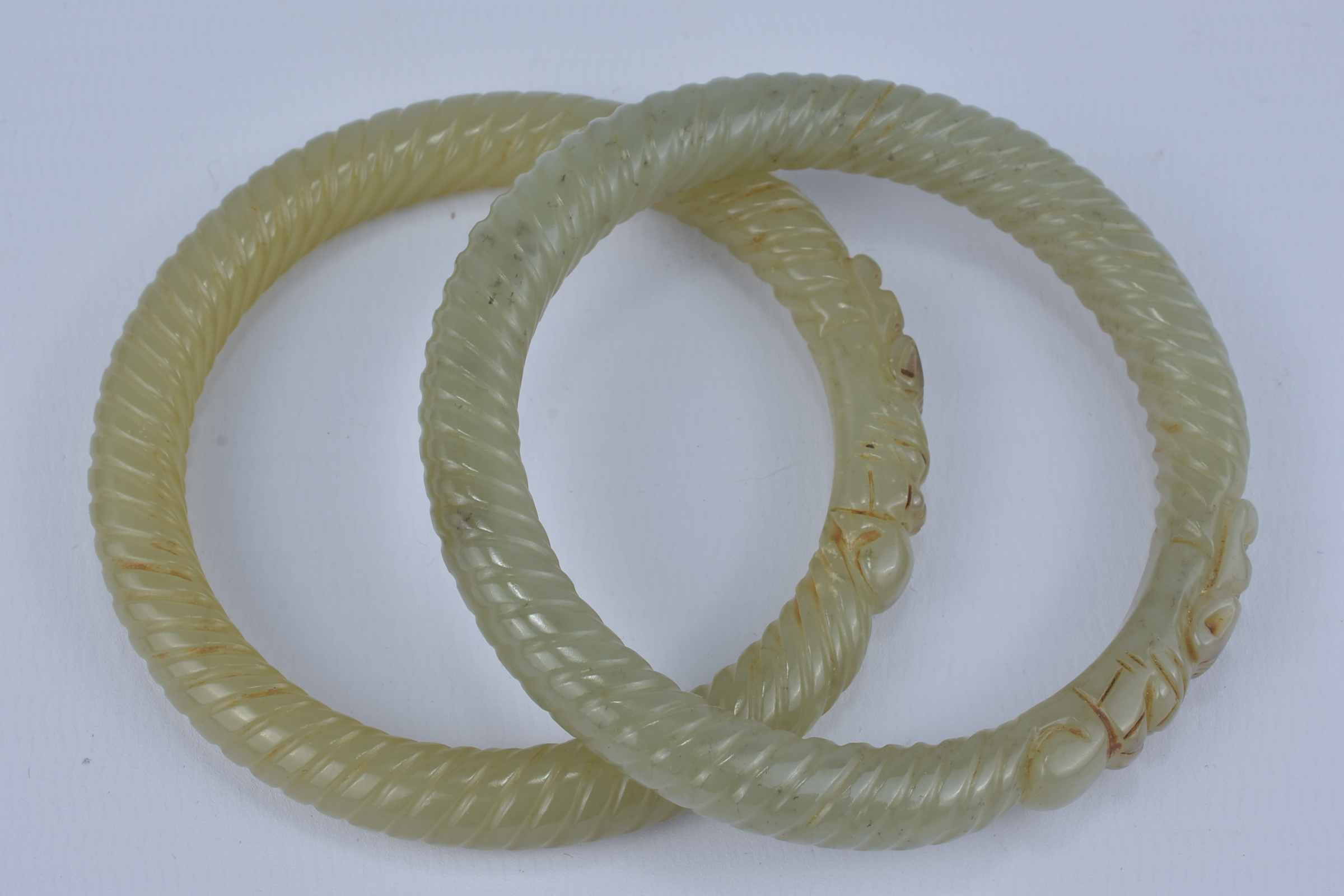 A Pair of Chinese carved Jade Bangles with twist design and dragon  heads. 8cm diameter - Image 2 of 2