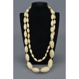 A long vintage graduated ivory beaded necklace