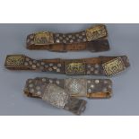 Three Eastern Leather Studded Belts with Bronze Tiger Panels, possibly Indian, largest approx. 101 c