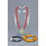 One beaded necklace with glass pendant and two beaded bracelets.