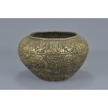 A Tibetan 19th century bronze bowl heavily decorated with dragons and eight Buddhist symbols. 14Cm x