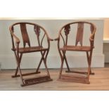 A pair of Chinese 20th century hardwood folding horseshoe armchairs with brass mounts throughout.