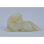 A Chinese jade carving of a recumbent lion with head turned backwards. 9cm width