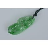 A Chinese green jadeite pendant carved with cricket on fruit with string. Size 3.5cm length