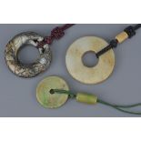 Three Chinese jade bi discs, one carved and two without decoration. 6Cm diameter, 5.5cm diameter and