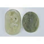 A Chinese pale celadon jade pendant surmounted with a carved dragon together with one other. 7Cm and