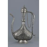 A large Persian repousse sliver alloy metal ewer with cover attached to chain. 44Cm tall