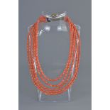 A five string coral beaded necklace with clasp (damage to clasp fitting)