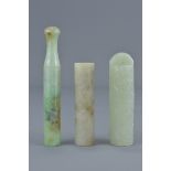 Three Chinese jade items including one cigarette holder, a jade hat piece and one long bead with ins