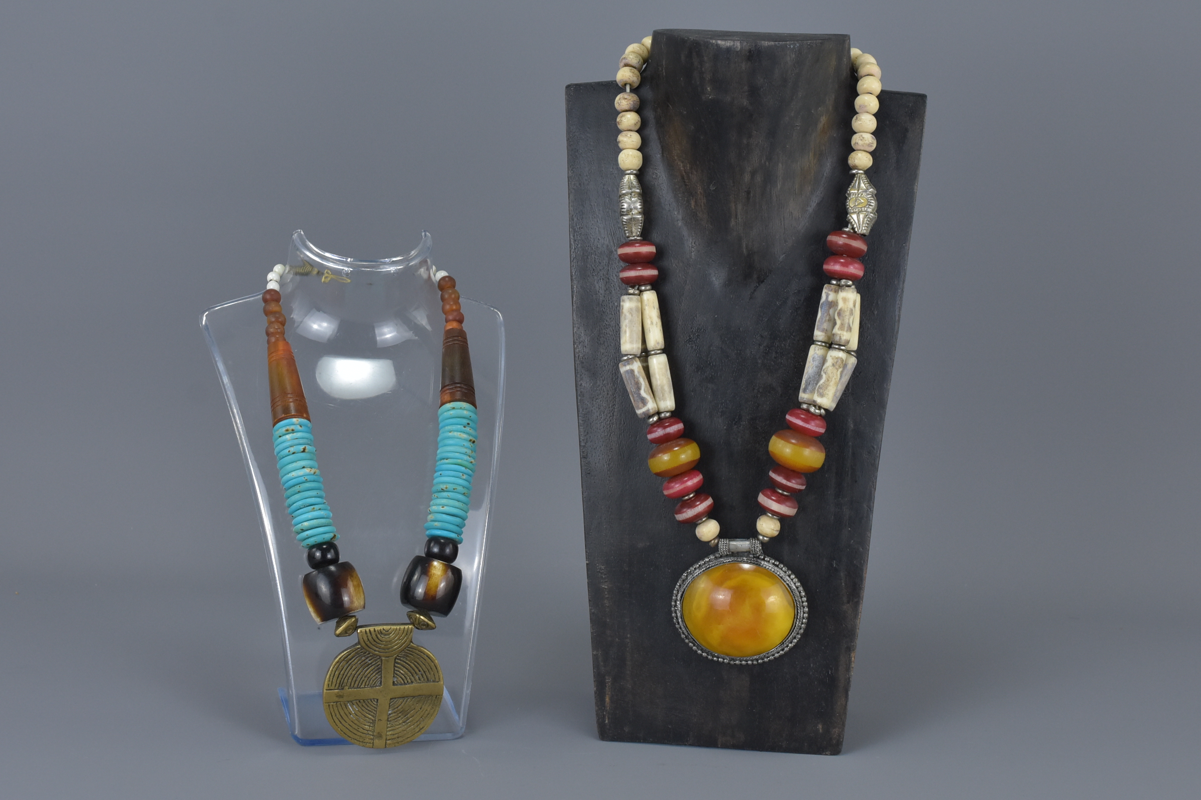 Two Ethnic Necklaces, one with wooden and turquoise coloured beads and large brass disc pendant, the