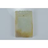 A Chinese pale celadon and russet jade plaque. Size 6.5cm x 4.5cm