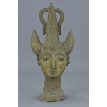 A Persian bronze sculpture of head with horned helmet. 28Cm tall