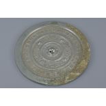 A Chinese Han dynasty or later circular bronze mirror with inscriptions and animal pattern with some