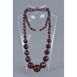 String of Seventy Three Faux Cherry Amber Faceted beads