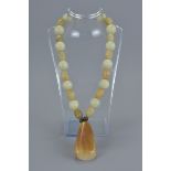 A jade beaded necklace with agate pendant.