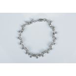 A white metal and diamond linked bracelet