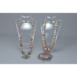 Two Asian white metal necklaces with stone inserts and drop pendants. (2)