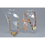 Three vintage agate, amber and white metal necklaces. (3)