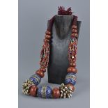 A large Moroccan beaded necklace with silver colour metal and enamel with coral coloured beads and s