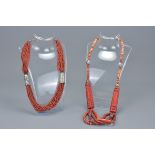 Two coral beaded necklaces with white metal spacers. (2)