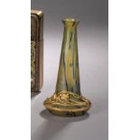 Vase en verre irisé vert. Monture à la base en métal doré à décor d'iris. Vers [...]