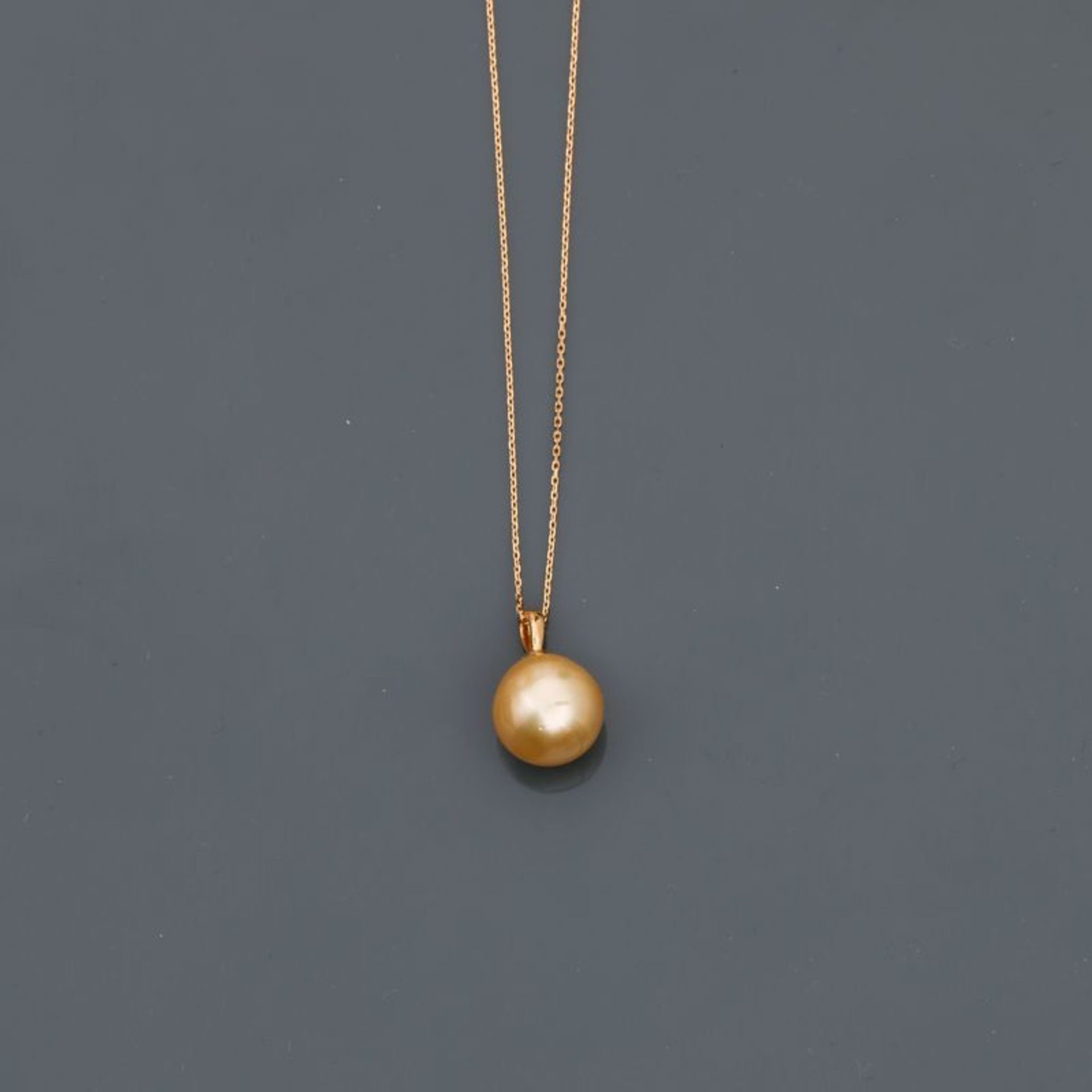 Fine chaîne et pendentif en or jaune, 750 MM, portant une perle " Gold " des Mers du [...]