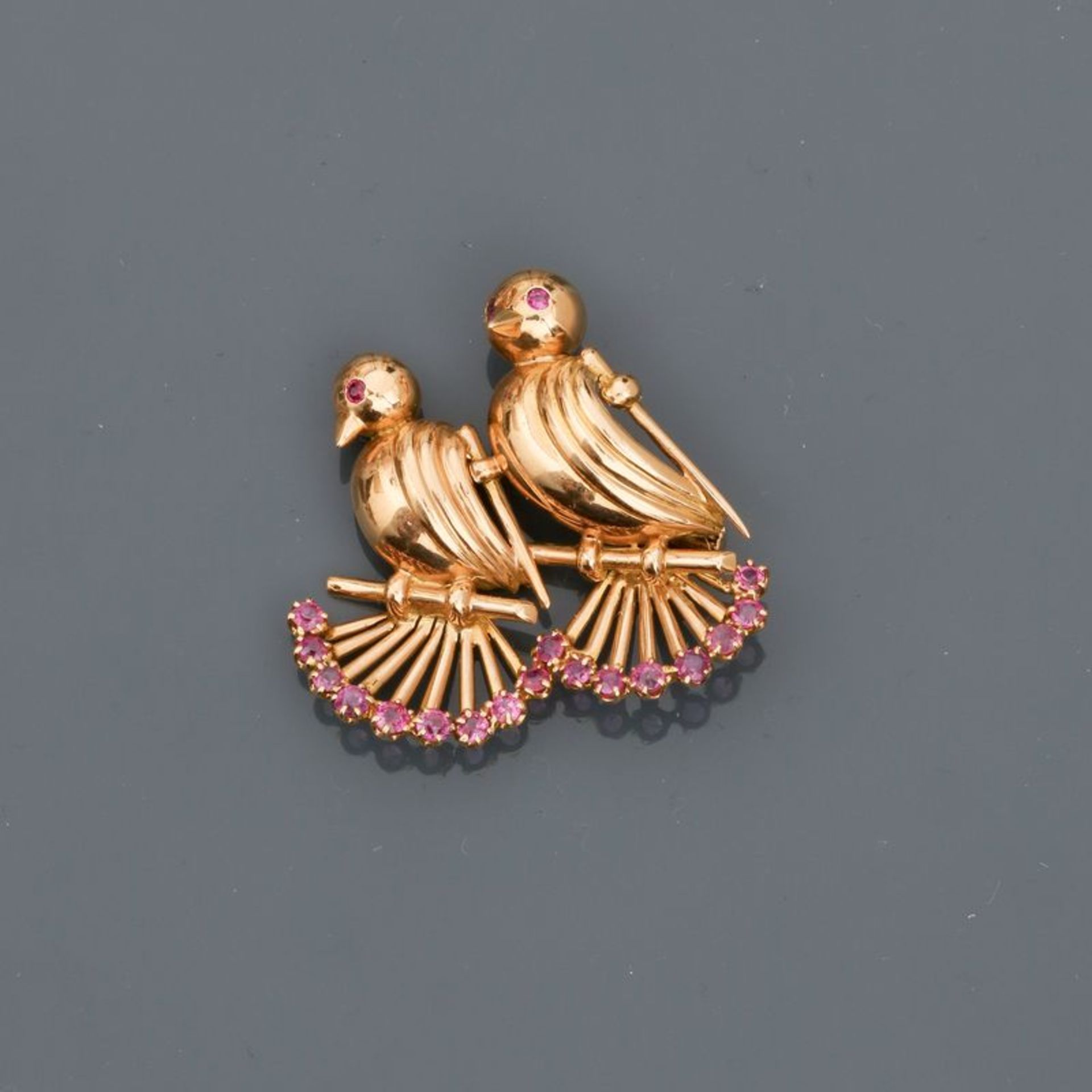 Broche dessinant deux oiseaux en or rose, 750 MM, ornés de rubis, dimensions : 3,5 [...]