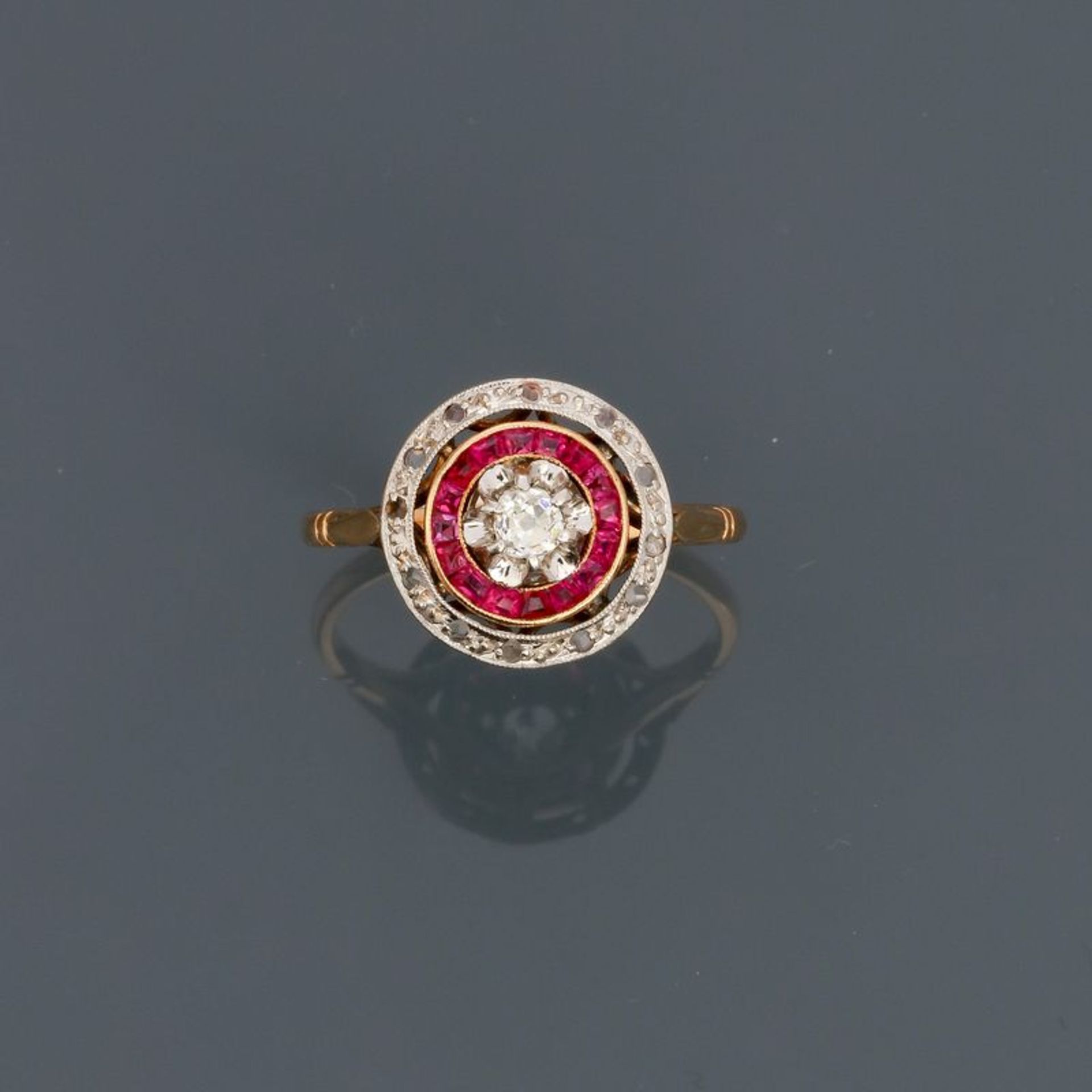 Bague ronde deux ors, 750 MM, recouverte de diamants et pierres rouges calibrées, [...]