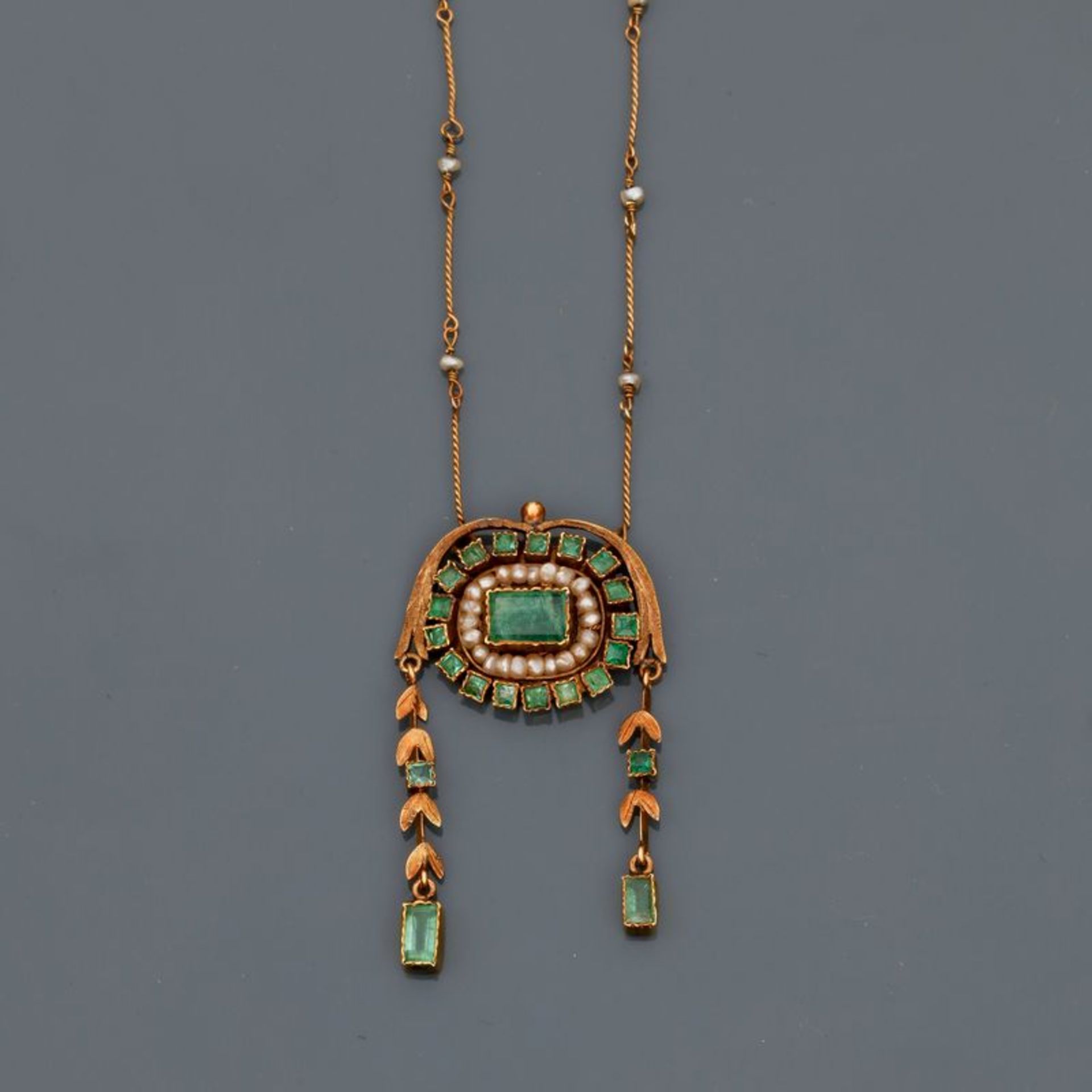 Fin collier en or jaune, 750 MM, ponctué de petites perles centré d'un motif à [...]