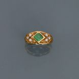 Bague en or jaune, 750 MM, centrée d'une émeraude entre deux motifs diamantés, [...]