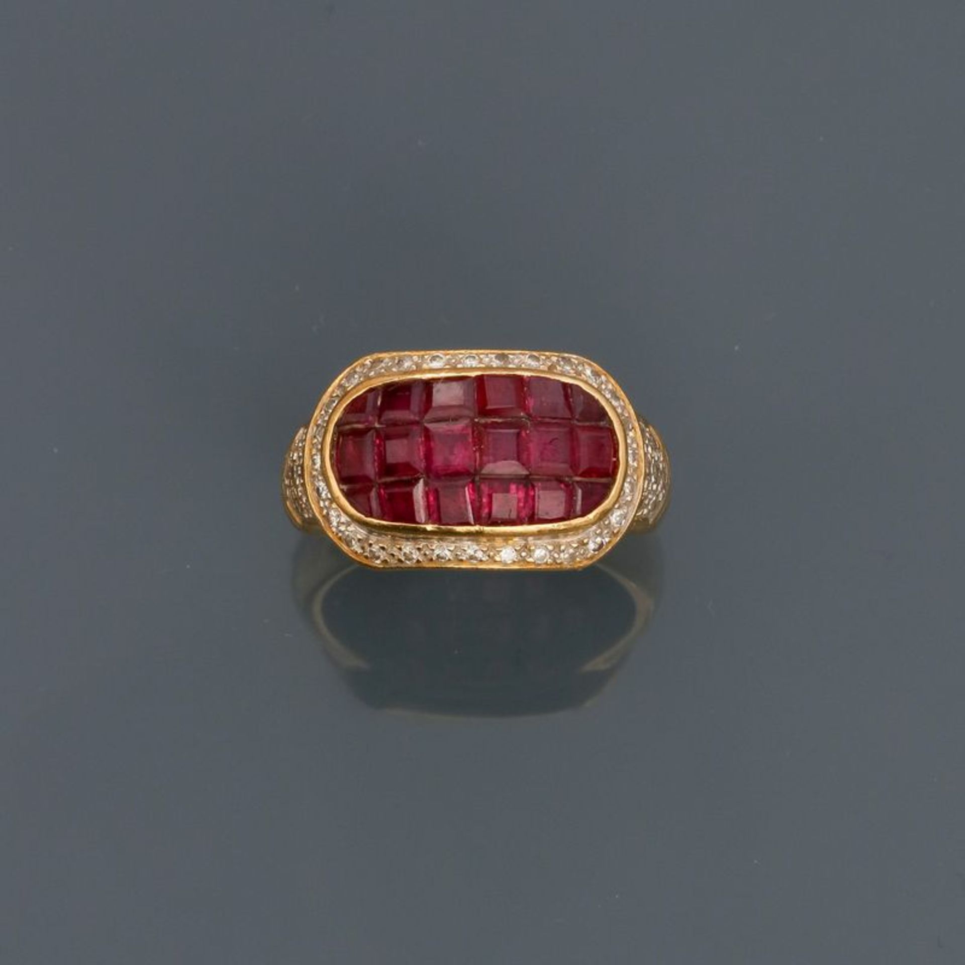 Bague en or jaune, 750 MM, ornée de rubis en serti invisible entourés et épaulés [...]