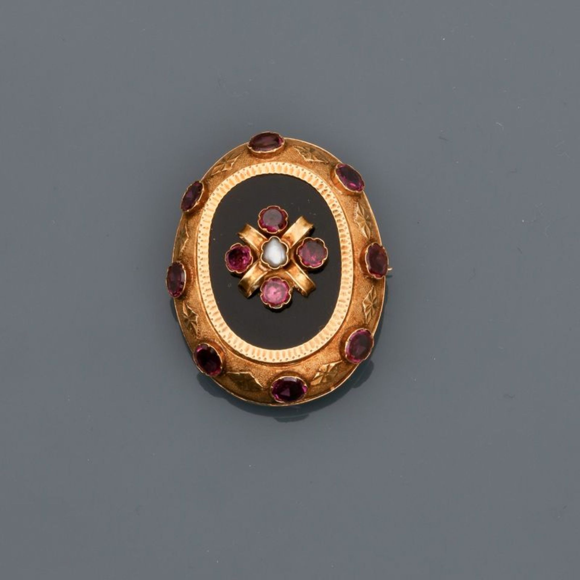 Broche en or jaune, 750 MM, ornée d'un onyx ovale dans une frise de pierres de [...]