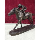 A sculpture of horse and rider by J Skeating, modelled in resin with antique bronze effect finish.
