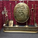 A set of Victorian brass fireside accessories including a screen, fender and irons.